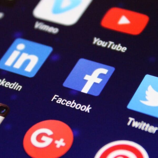 Close-up of a smartphone screen showing various social media app icons such as Facebook and Twitter.