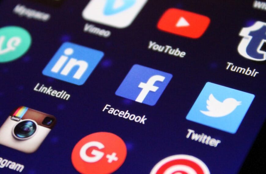 Close-up of a smartphone screen showing various social media app icons such as Facebook and Twitter.